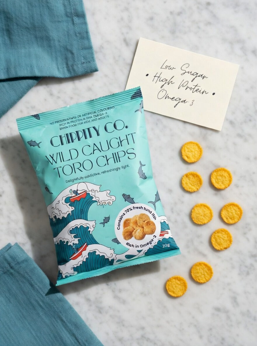 Chippity Co. Wild Caught Toro Chips packet on white marble with small realistic Toro Tuna Chips and a note card reading 'Low Sugar • High Protein • Omega-3' – featured in guide to choosing low-sugar snacks in Singapore